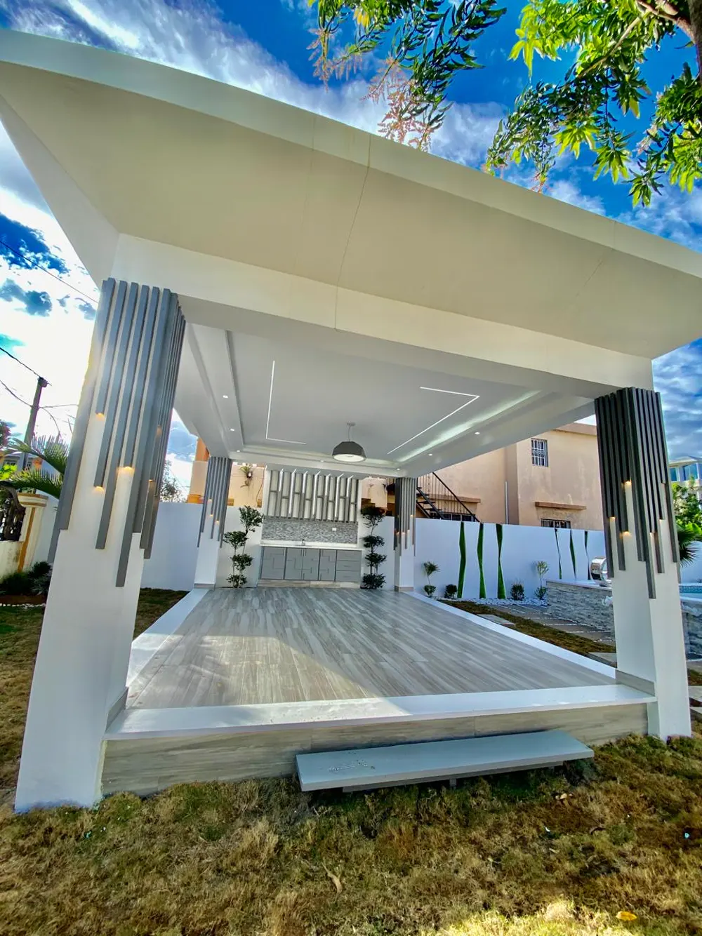 Cabaña social blanca junto a la piscina de una villa privada