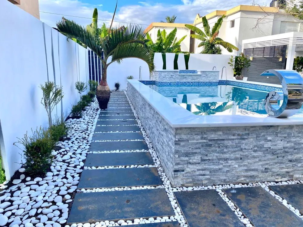 Camino de piedra y canto rodado junto a la piscina