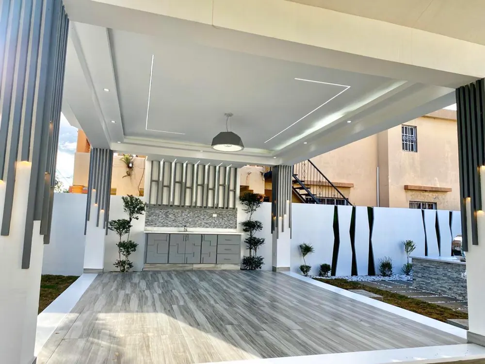 Terraza techada con cocina exterior y columnas de listones